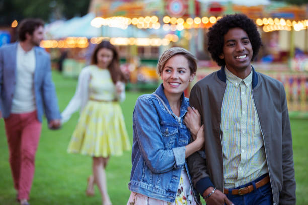 joven pareja multirracial sonriendo mientras camina en el parque de atracciones - 24295 fotografías e imágenes de stock