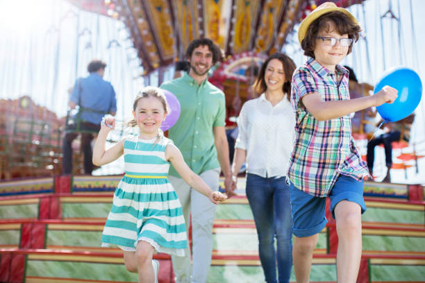 istock Children running in front of carousel, parents following them 534576837