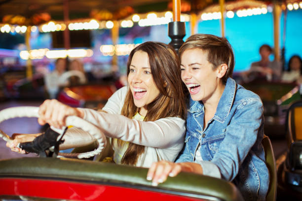 istock Two cheerful women on bumper car ride in amusement park 534576849