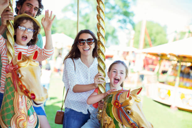 rodzina na karuzeli w parku rozrywki - fun mother sunglasses family zdjęcia i obrazy z banku zdjęć