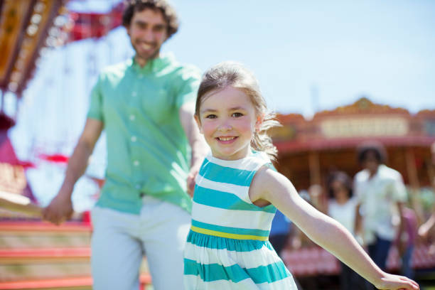 istock Girl pulling her father in amusement park 534577077