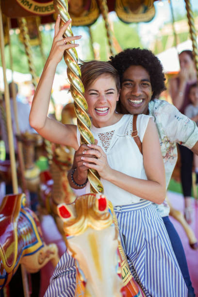 istock Young multiracial couple smiling on carousel in amusement park 534577173