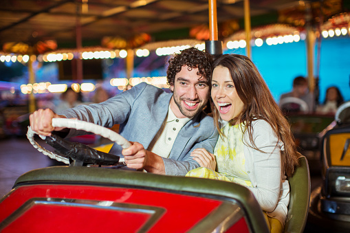 Two young women having a fun bumper car ride at the amusement park.