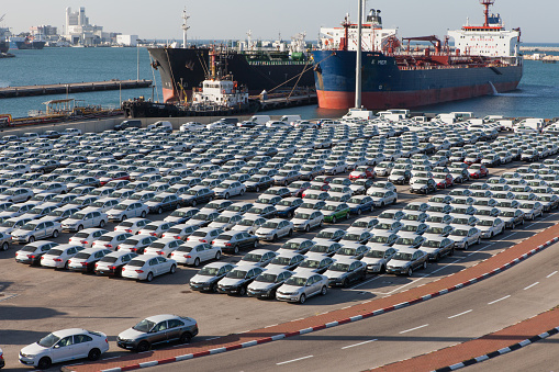 Haifa, Israel - January 23, 2015: Rows of new cars covered in protective white sheet parked in Haifa's port platform.