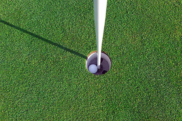 Photo of Golf ball and Flagstick of  Manicured grass of putting green