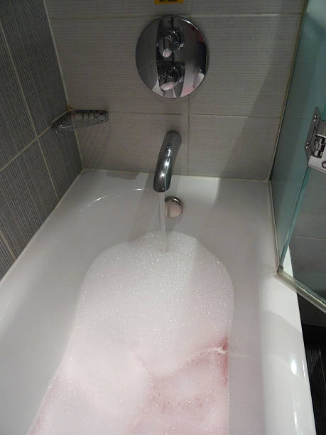 istock Modern white bathroom suite / bath, black-white tiles, pink bubbles bubblebath 534602373