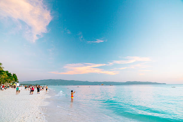 Boracay island, Philippines - February  25, 2014: Sunset on the Boracay island. People relaxing on the beach. Boracay is a world famous Philippino island with a great white coral beach and crystal clear water.