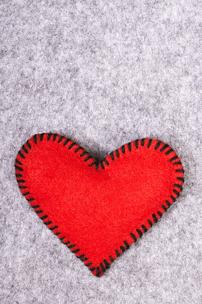 Woman sews red heart shaped toy by needle, body part, conceptual symbol of love and soul pain treatment, happy Valentine day
