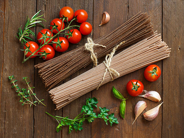 artigiano italiano spaghetti, pomodorini e erbe - pasta whole wheat spaghetti raw foto e immagini stock