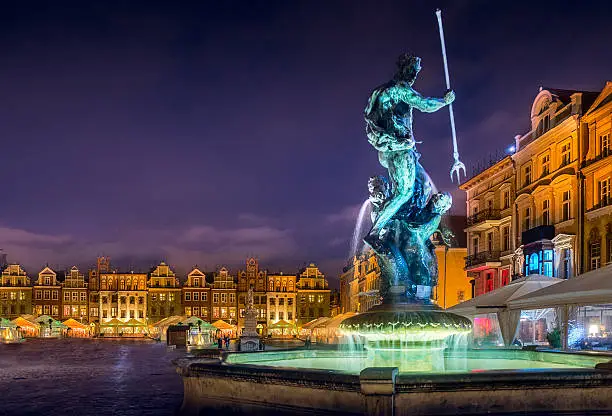 Poznań, western city in Poland at night with the statue of Fountain of Neptune