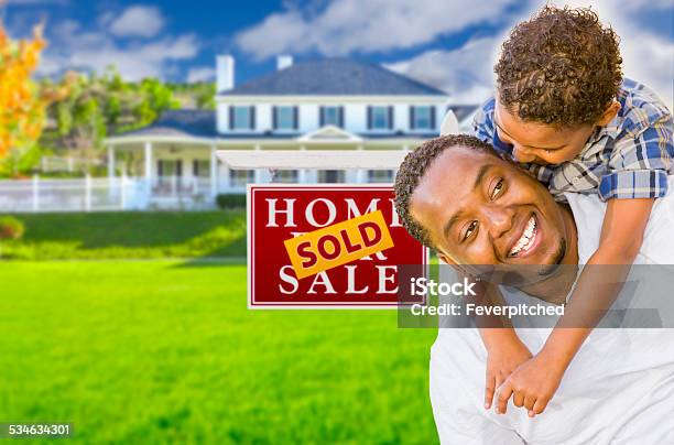 Father And Son In Front Of Sold Sign And House Stock Photo - Download Image Now - For Sale Sign, 2015, 30-39 Years