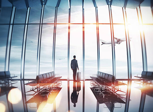 Businessman at airport near the window Man near panoramic window looking at the airplane business journey stock pictures, royalty-free photos & images