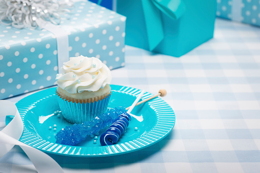 This is a close up photo of candy and a cupcake for a little boys first birthday party. There is a lot of space for copy on the right.
