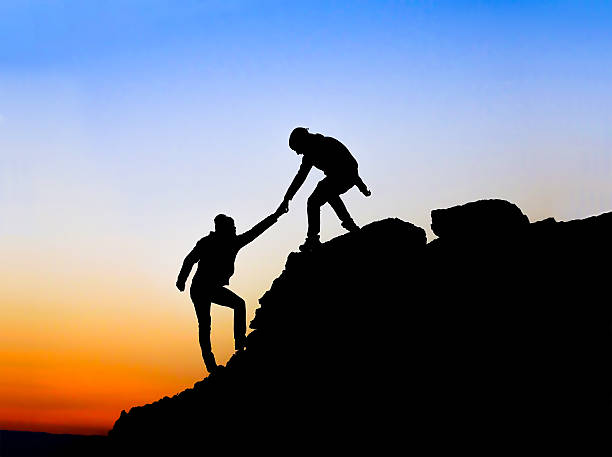istock Silhouette of helping hand between two climber 534637287