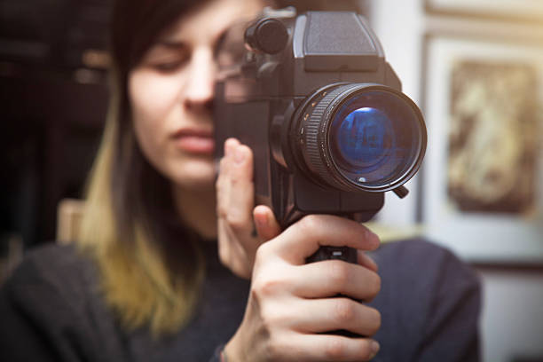 istock Beautiful young woman with video camera 534639819