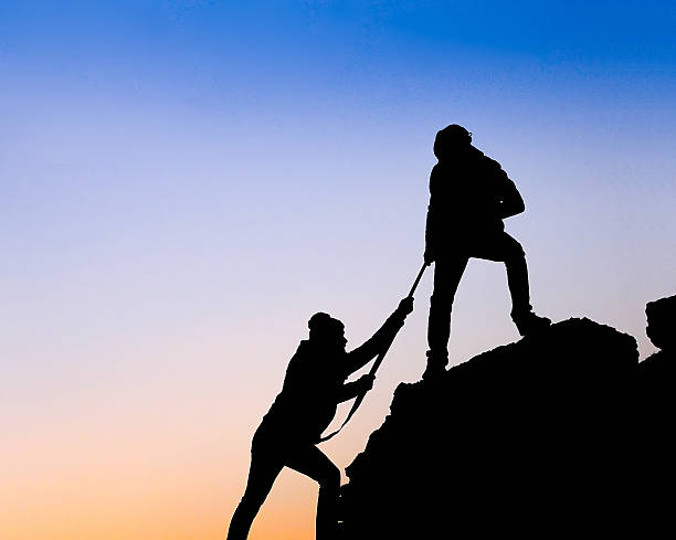 istock Silhouette of helping hand between two climber 534641233