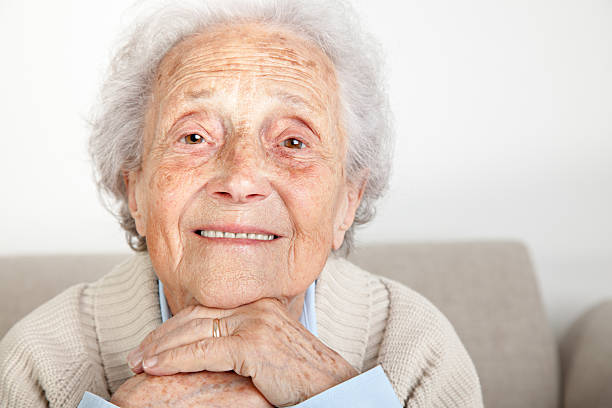 istock Happy Senior woman sitting on bench and looking into camera 534644205