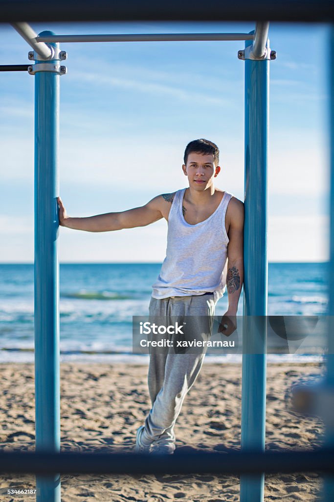 Young man doing street workout at the beach One young men portrait on a street workout structure at the beach. 20-29 Years Stock Photo