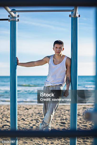 Young Man Doing Street Workout At The Beach Stock Photo - Download Image Now - 20-29 Years, 2015, 25-29 Years