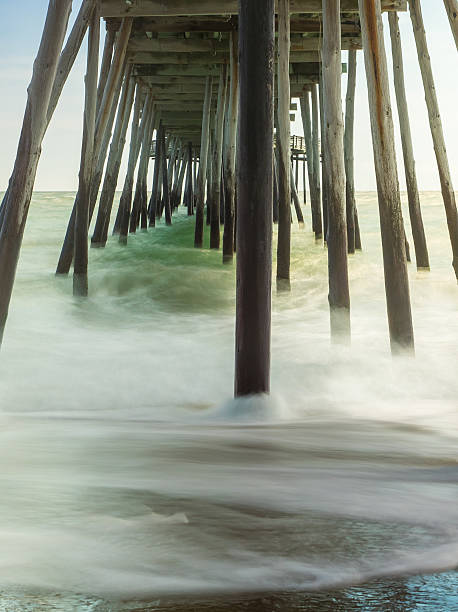 Timed Exposure: Waves under a Wooden Pier stock photo
