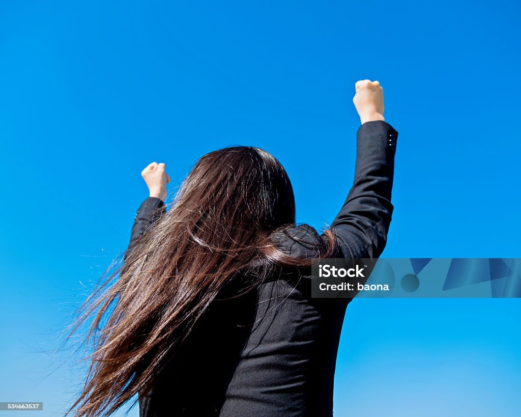 Successful businesswoman Rear view of successful businesswoman with arms outstretched 2015 Stock Photo