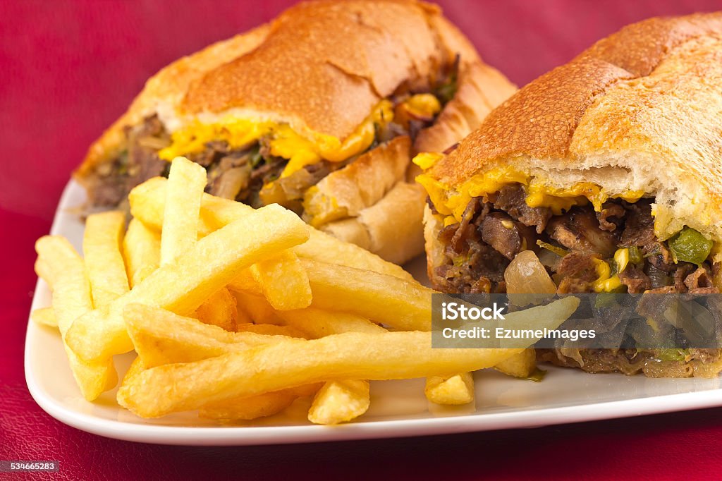 Philly Cheesesteak A messy Philly Cheesesteak with onions peppers and mushrooms, fries on the side 2015 Stock Photo