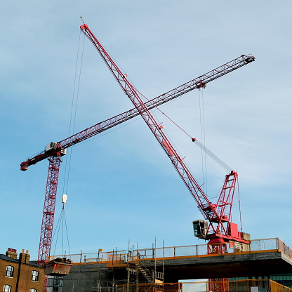 Two red cranes at construction site