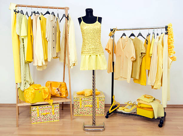 istock Dressing closet with yellow clothes arranged on hangers. 534667079