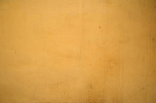 istock Texture of old wall covered with yellow stucco 534668849