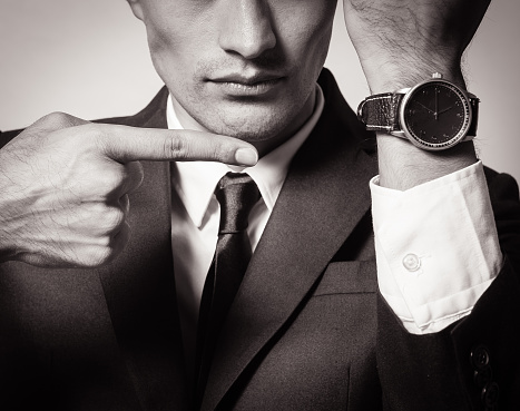 Business man showing time on his wrist watch (black and white image).