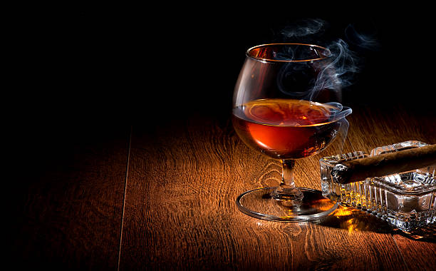 Cognac and cigar Cognac and cigar on ashtray on a wooden table cigar photos stock pictures, royalty-free photos & images