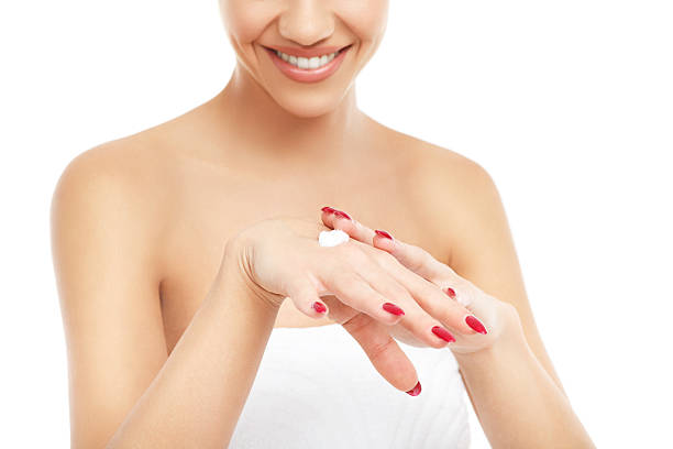istock Young woman applying body cream on hand 534670223