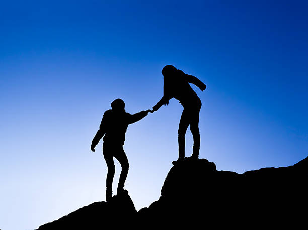 istock Silhouette of helping hand between two climber 534680871