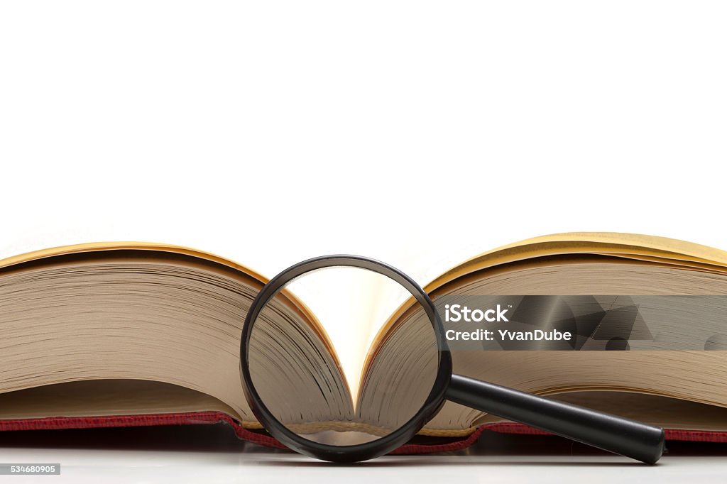 open book with magnifying glass open book with magnifying glass over white background 2015 Stock Photo