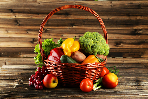 Vegetable in basket on brown wooden background