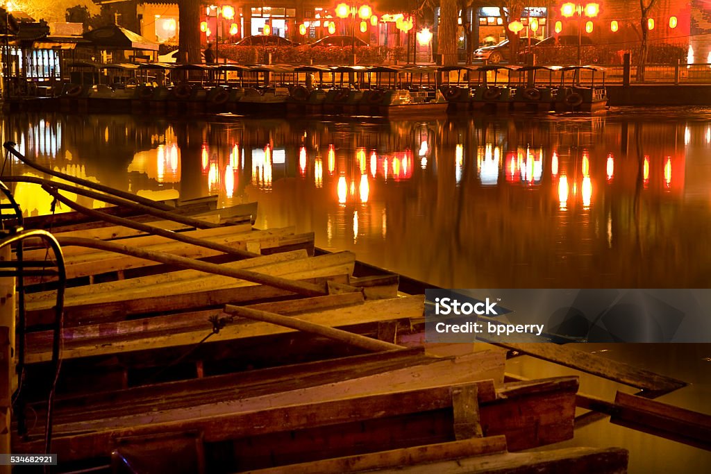 Wooden Boats Houhai Lake Beijing China at Night Wooden Boats on Houhai Lake with Lights of Bars and Restaurants in background, Beijing, China.  Hohai is the old swimming hole in the City and is now surrounded by bars and restaurants and is one of the well-known night districts in Beijing. 2015 Stock Photo