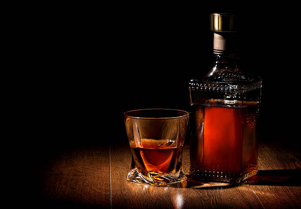 Whiskey on table Bottle and glass of whiskey on a wooden table cognac stock pictures, royalty-free photos & images