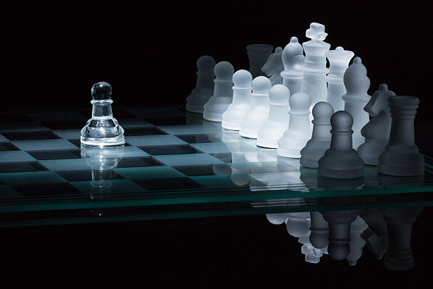 chess pawn against all spotlight stock photo