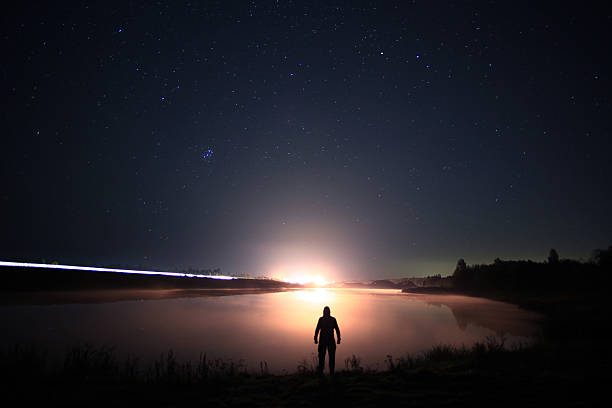 istock night man at Lake starry sky space alien 534698149