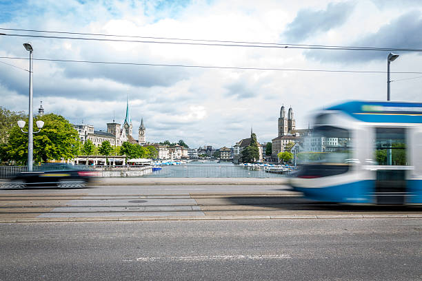 Tram and Car on a Bridge of Zurich, Switzerland A tram passing by the city center of Zurich in Switzerland. The tram is blurred due to motion and long exposure. zurich photos stock pictures, royalty-free photos & images