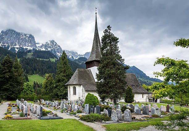 церковь и кладбище в пасмурный день, швейцария - cemetery hill стоковые фото и изображения