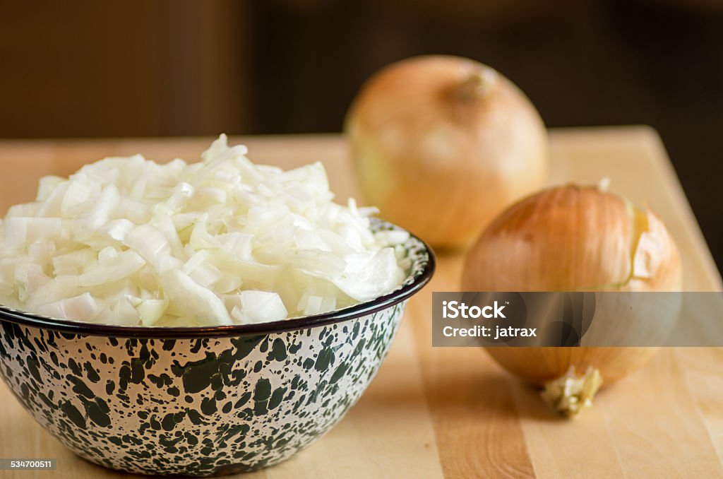 Bowl of chopped onions on cutting board Bowl of freshly chopped onions with onions on cutting board 2015 Stock Photo
