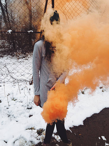 Girl holding smoke orange bomb Young girl holding smoke orange bomb leggings street style stock pictures, royalty-free photos & images