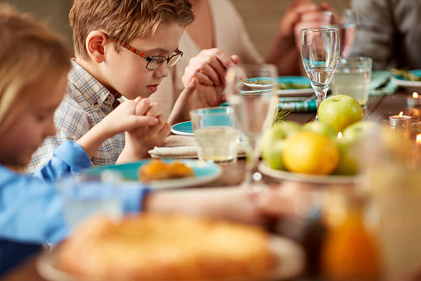 Saying grace Little boy and his family saying grace before dinner saying grace stock pictures, royalty-free photos & images