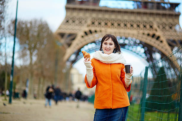 istock Young woman in Paris with coffee and croissant 534713491