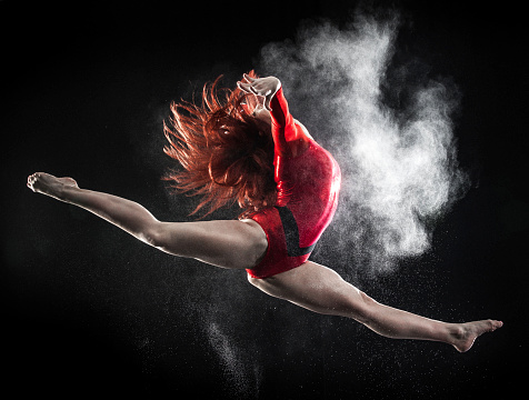 Young woman doing gymnastics jump