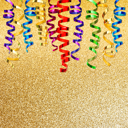 colorful streamer over golden shiny background. party decoration