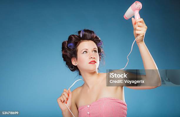 Girl With Curlers In Hair Holds Hairdreyer Stock Photo - Download Image Now - 2015, Adult, Beauty Treatment
