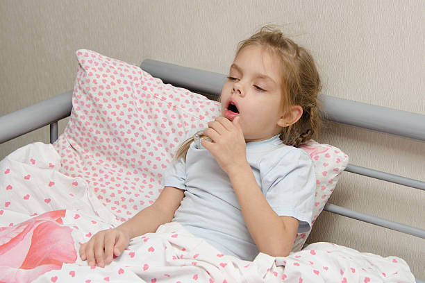 Diseased girl lying in bed coughing Six year old girl coughs diseased lying in bed with a thermometer on the mouse bronchitis stock pictures, royalty-free photos & images