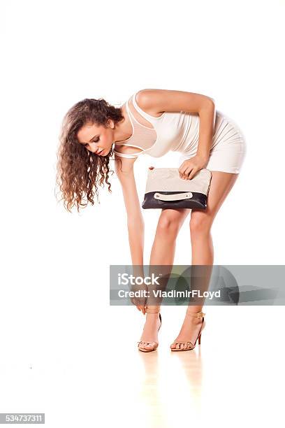 Pretty Girl In A Short White Dress Adjusting Her Sandals Stock Photo - Download Image Now